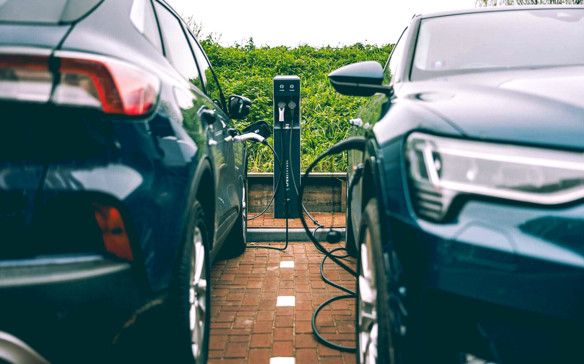 Twee auto's bij laadinfrastructuur.
